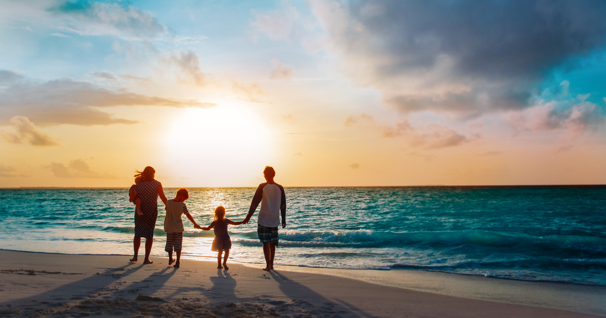 Une famille aidante profite du coucher de soleil sur la plage 
