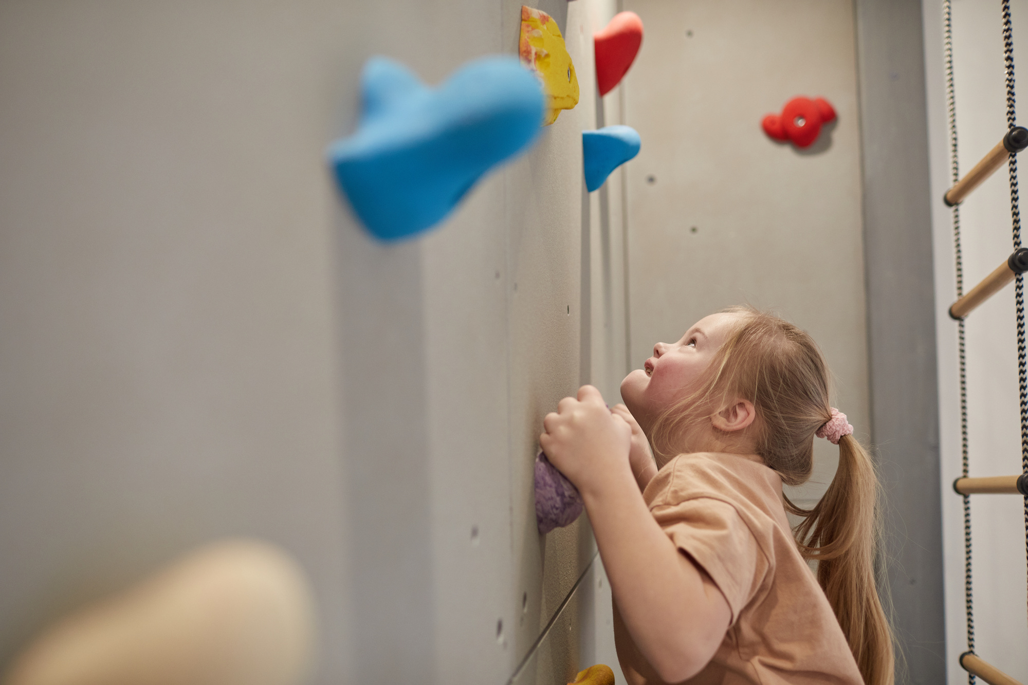 Une jeune fille atteint de trisomie 21 gravit un mur d'escalade 